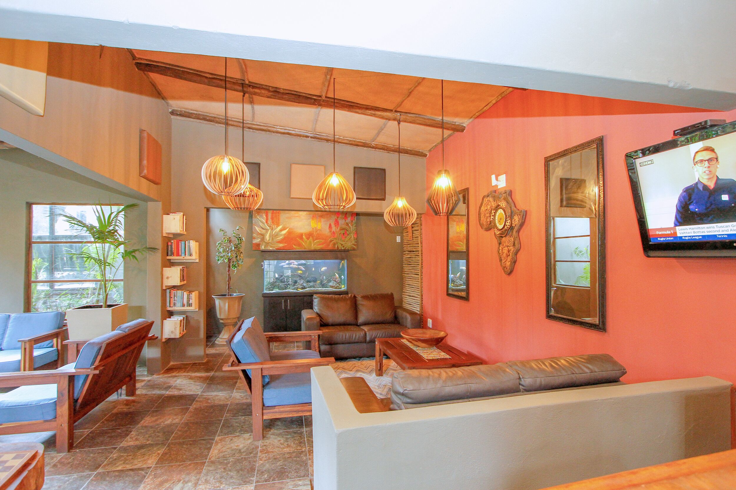 A spacious living area with a television, comfortable seating, and a bookshelf.
