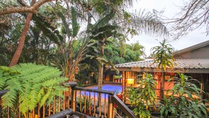 A wooden staircase leading to a pool area surrounded by lush tropical vegetation. - Umlilo Lodge (St. Lucia)
