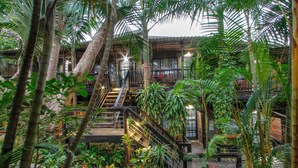 A multi-level building with a staircase surrounded by lush greenery and plants. - Umlilo Lodge (St. Lucia)