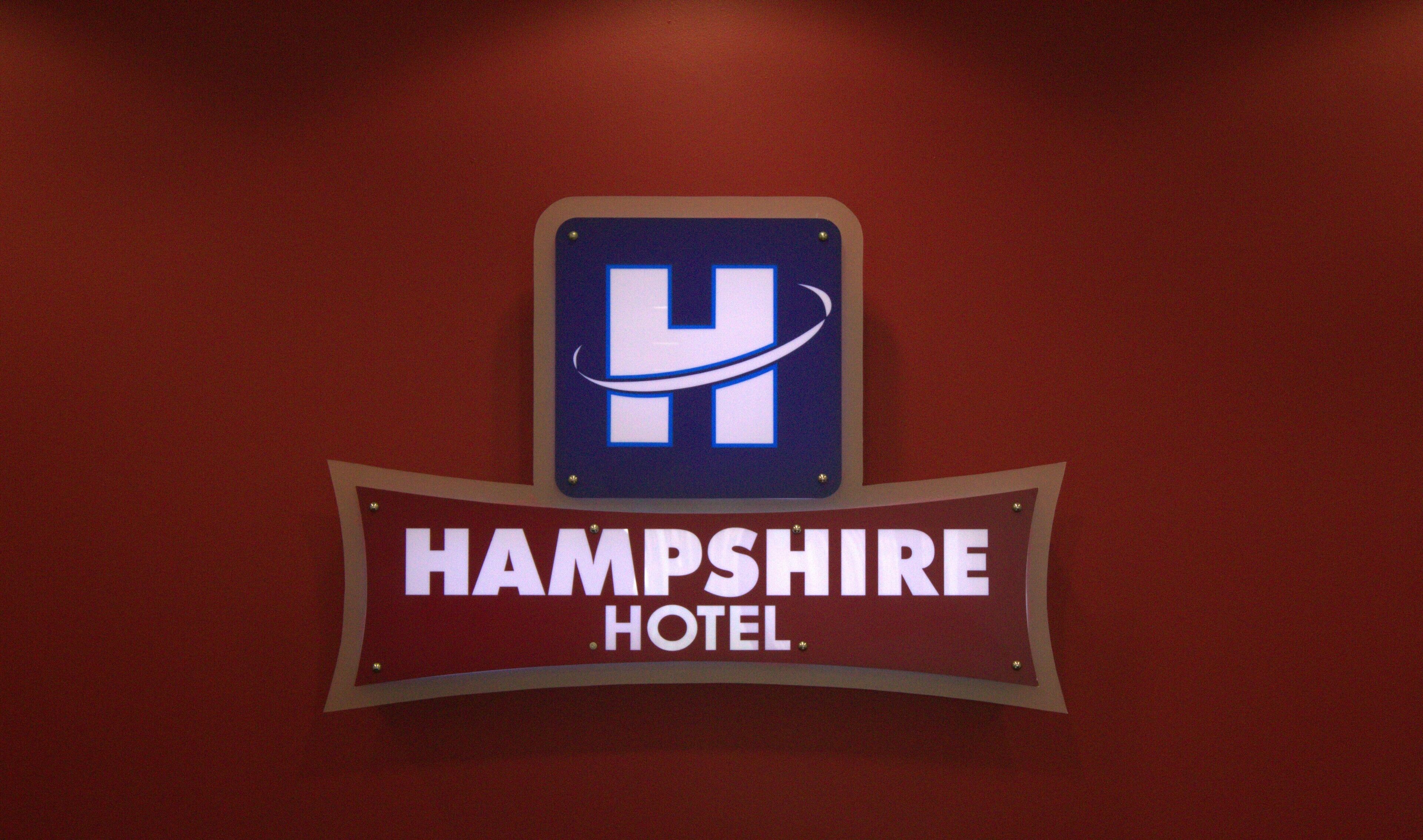 A sign for Hampshire Hotel with a blue and white logo.