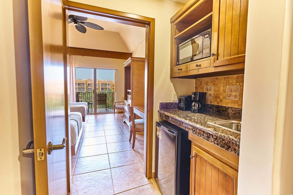 A kitchen with wooden cabinets, a microwave, and a coffee maker.