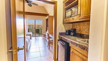 A kitchen with wooden cabinets, a microwave, and a coffee maker.
