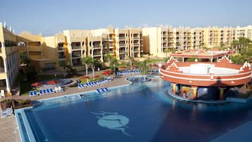 Un resort con una gran piscina, varios balcones y una fuente central.