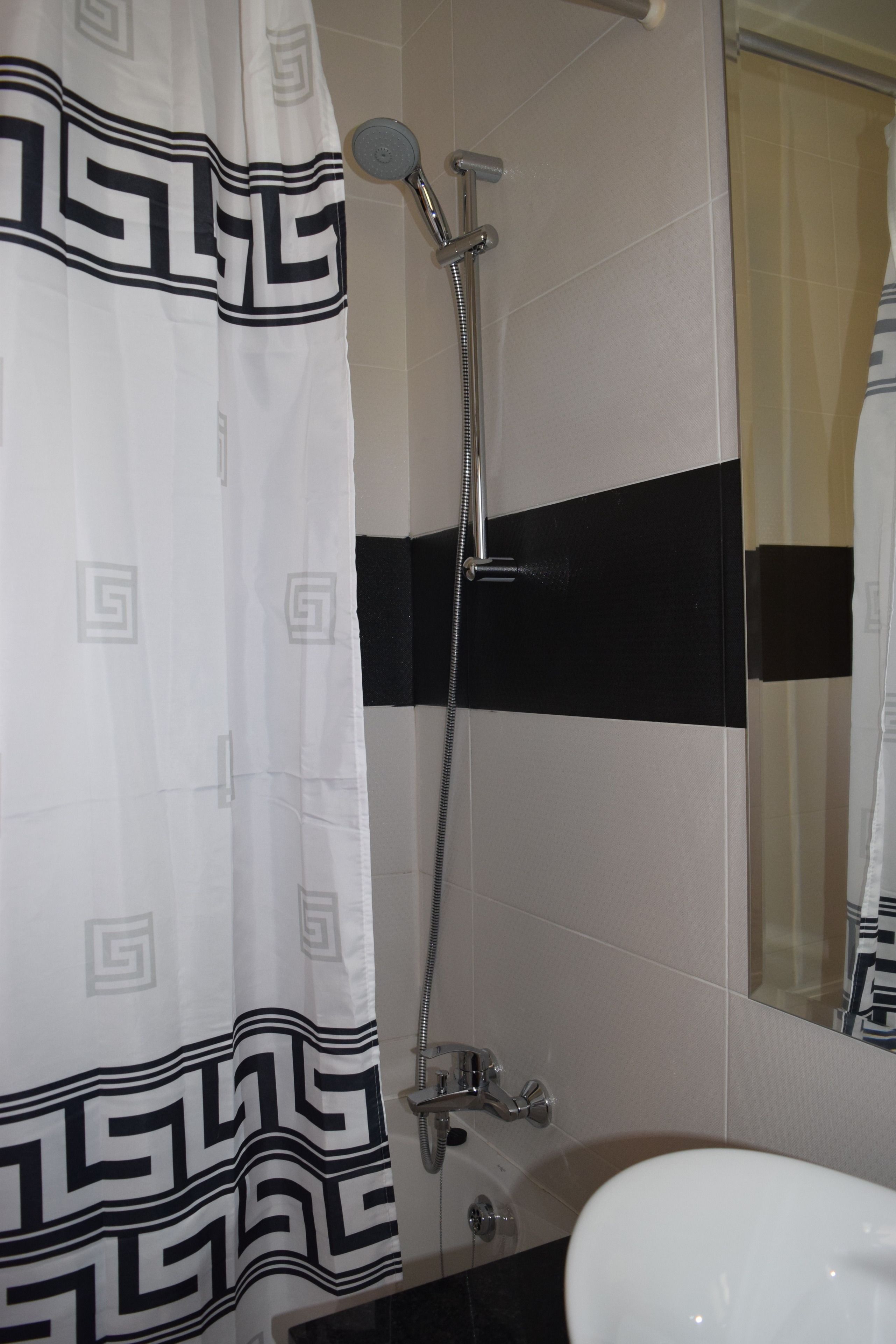 A bathroom with a shower, a toilet, and a sink.