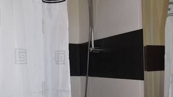 A bathroom with a shower, a toilet, and a sink.