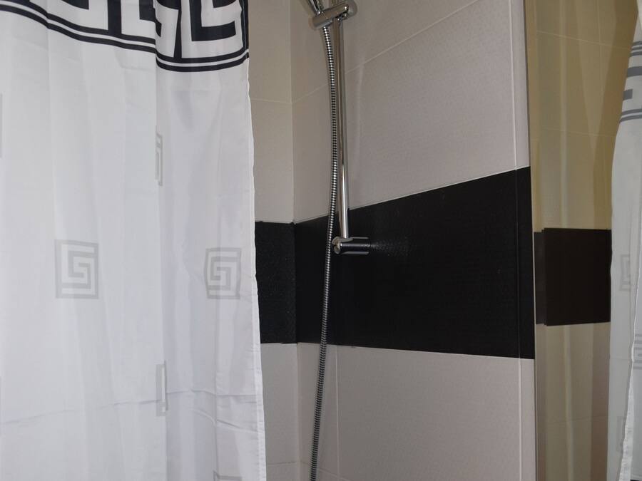 A bathroom with a shower, a toilet, and a sink.