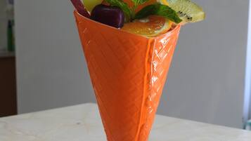 Un postre en un cono de vidrio sobre un plato blanco, con una cuchara.