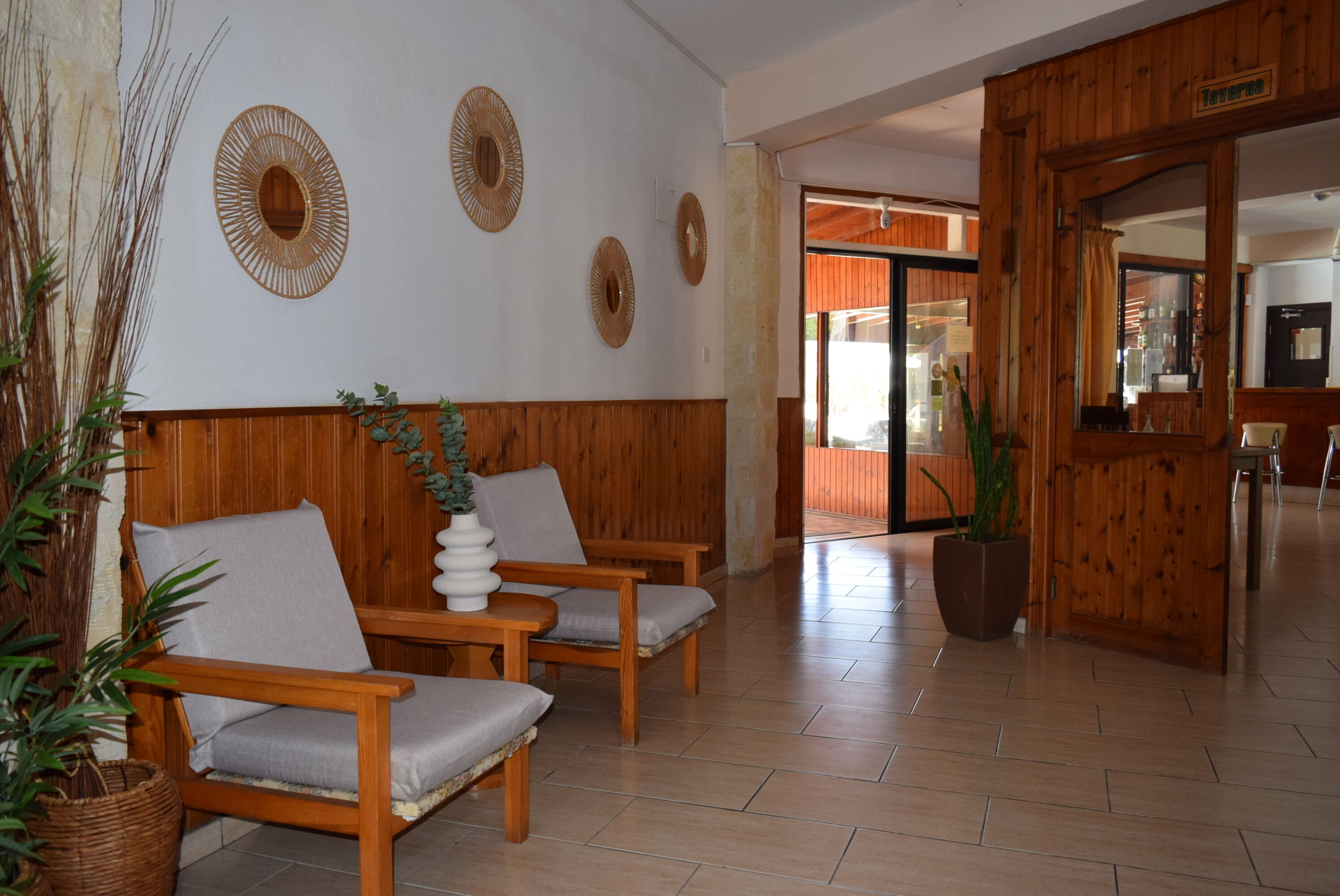 A reception area with wooden paneling, a reception desk, and two chairs with cushions.