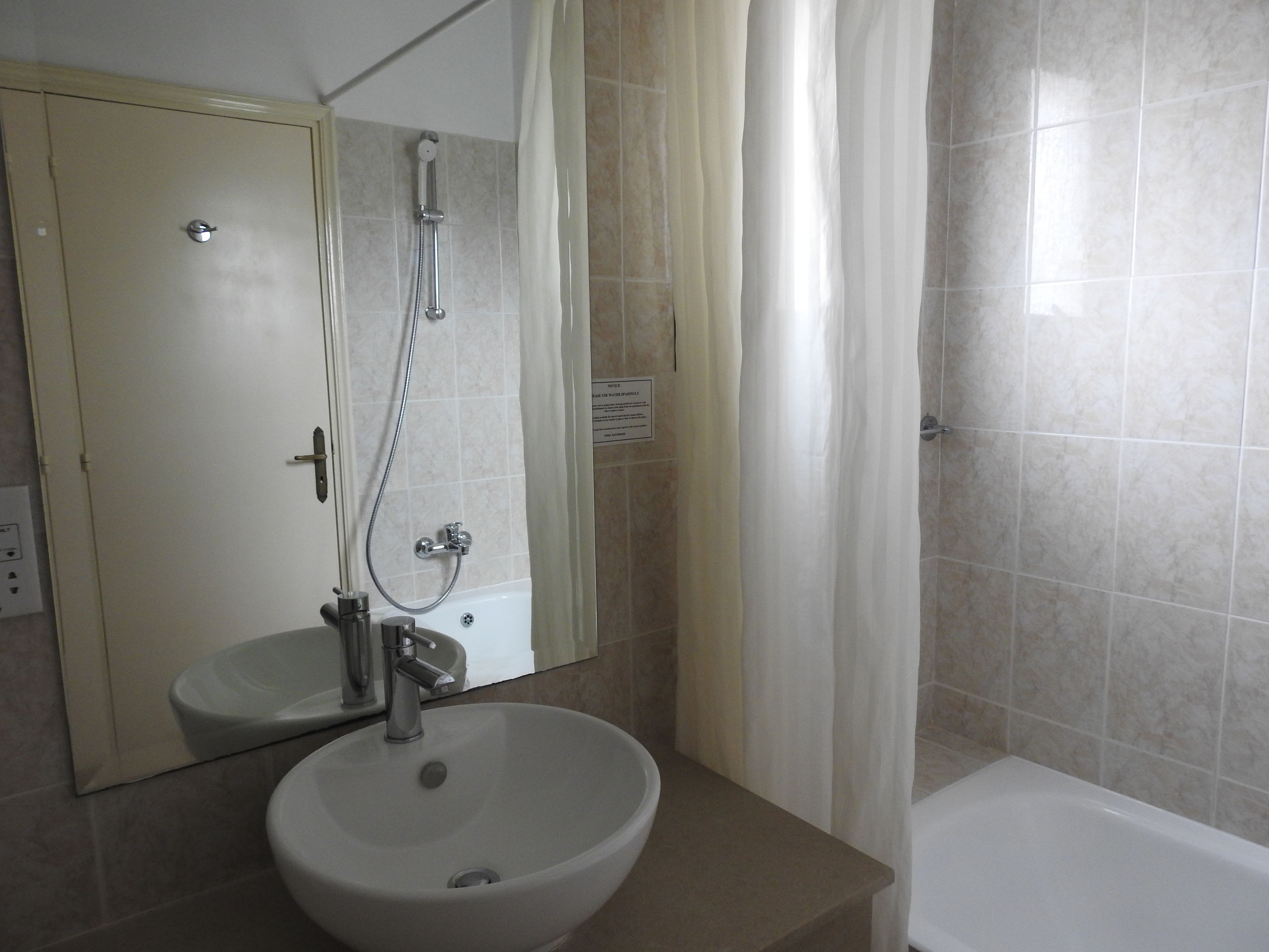 Une salle de bain équipée d’un lavabo, d’un miroir, d’une douche et d’une baignoire.