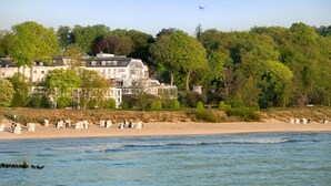 A coastal hotel with multiple buildings, a sandy beach, and a view of the sea. - Strandhotel Ostseeblick (Heringsdorf)