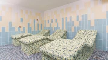 Relax in style with three comfortable reclining chairs against a unique, patterned wall.