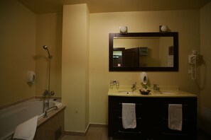 A bathroom with a bathtub, two sinks, a mirror, and a telephone. - Levoslav House Villa (Sibiu)
