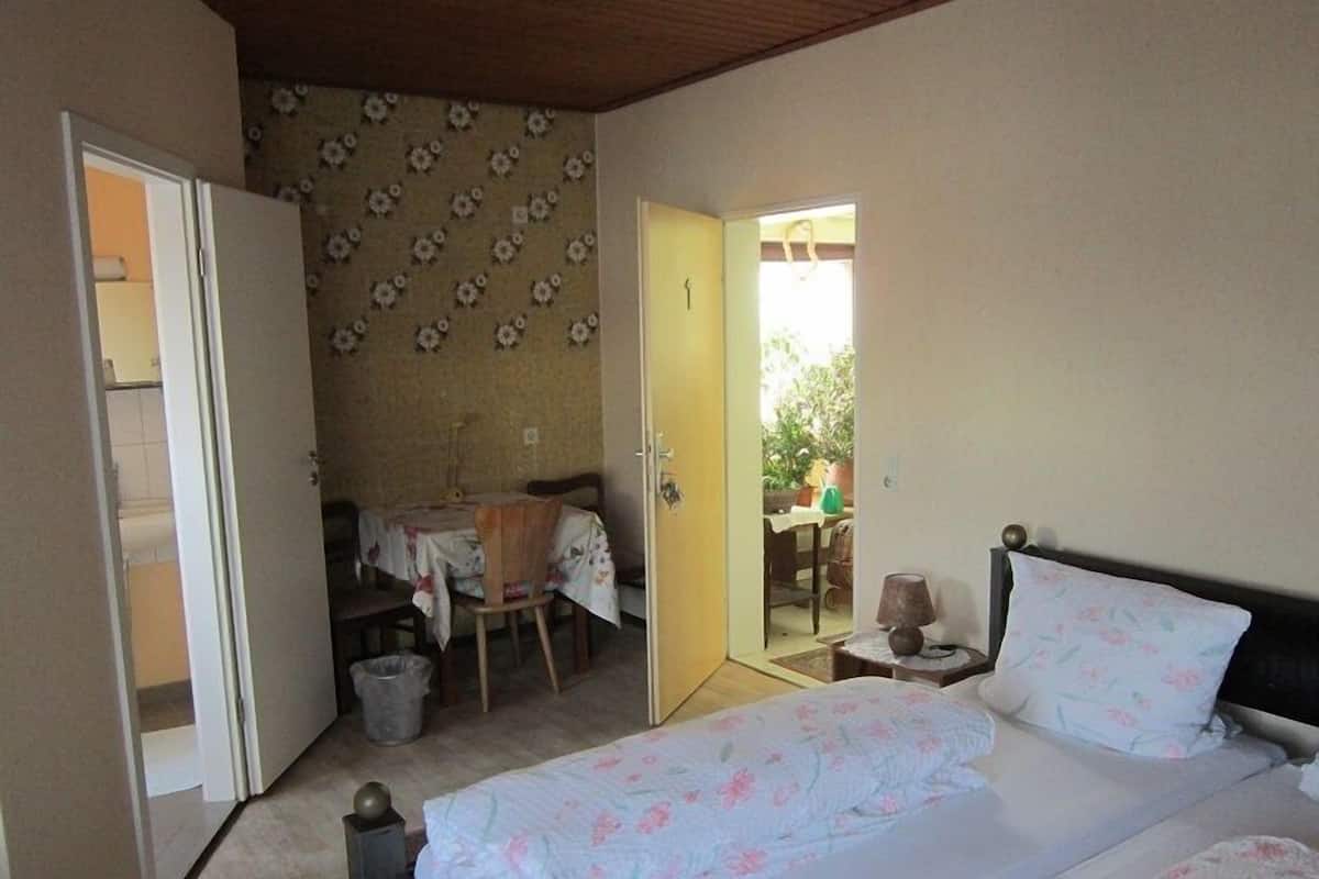 Une chambre à coucher avec un lit, une petite table et une chaise.