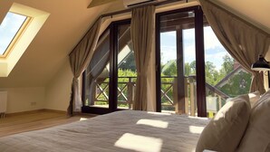 A bedroom with a large bed, skylight, and a view of greenery outside. - Karlamuiza Country Hotel (Cesis Municipality)