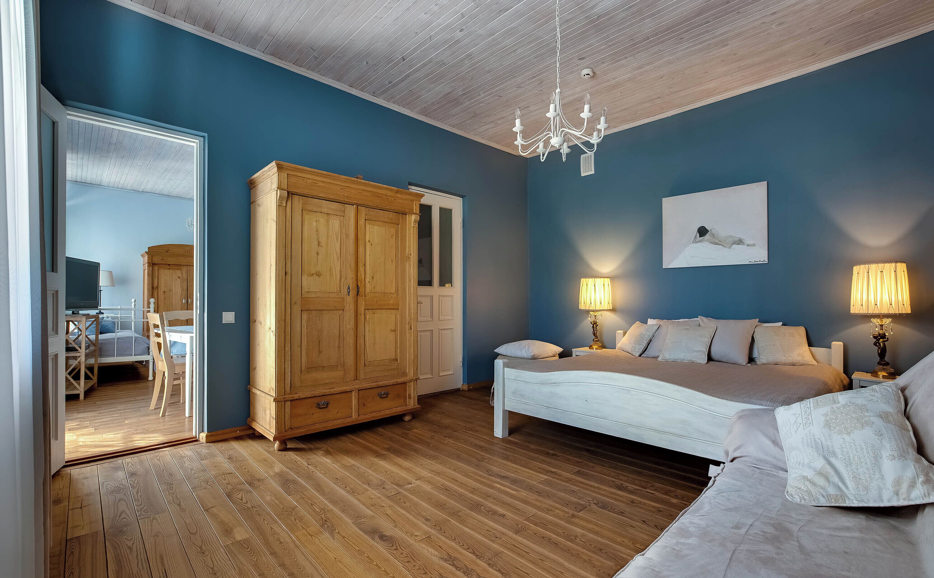 Una camera da letto con un letto, lampade da comodino, un armadio e un lampadario.