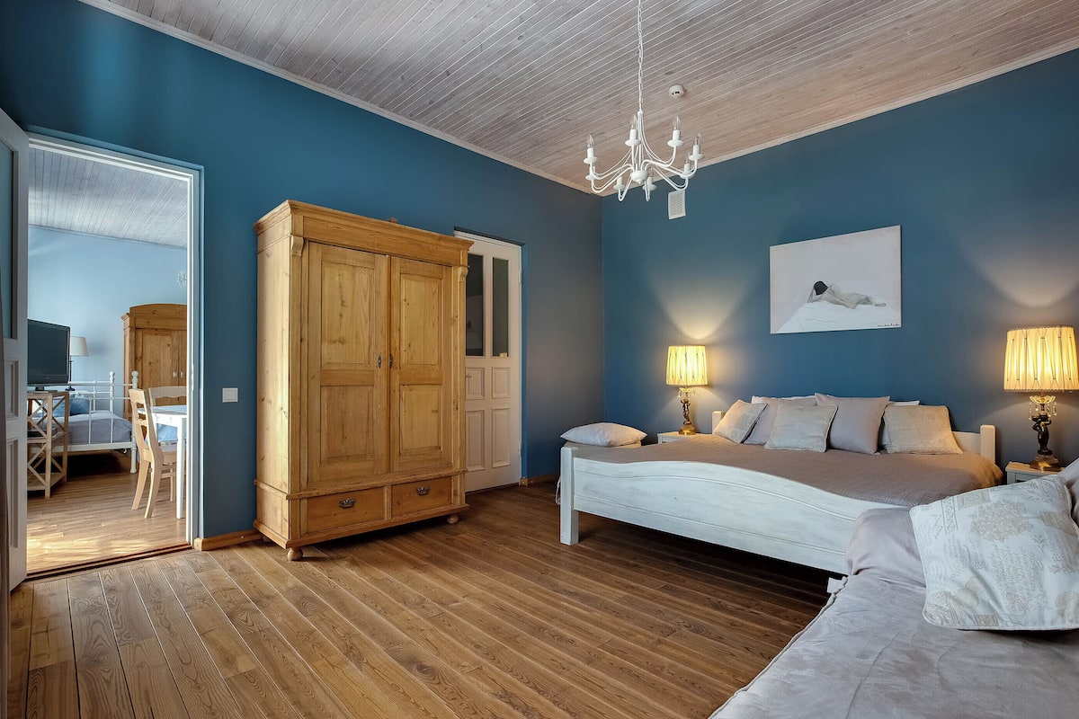 Un dormitorio con cama, lámparas de noche, armario y candelabro.