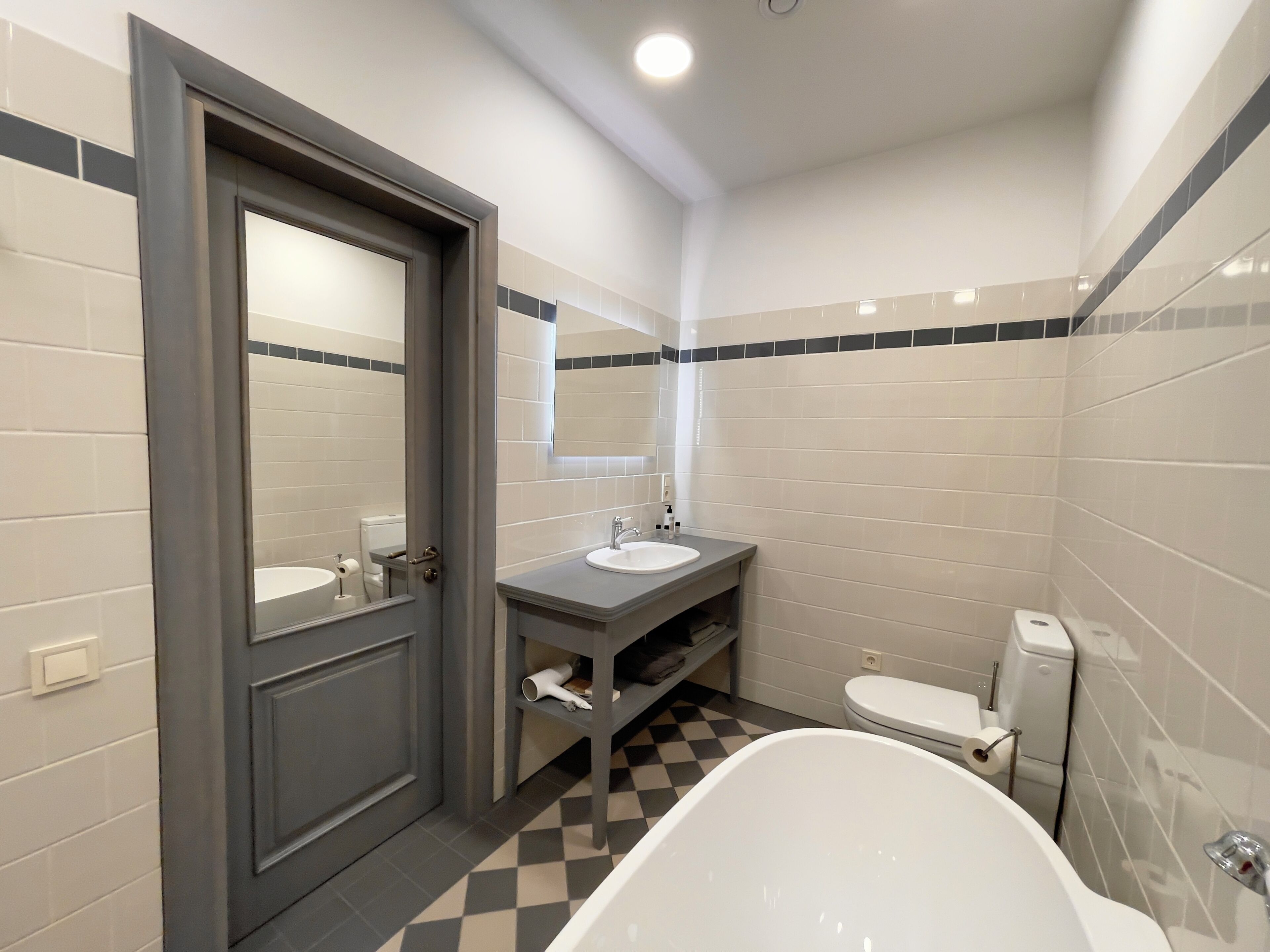 A modern bathroom with a large bathtub, a sink, and a toilet.