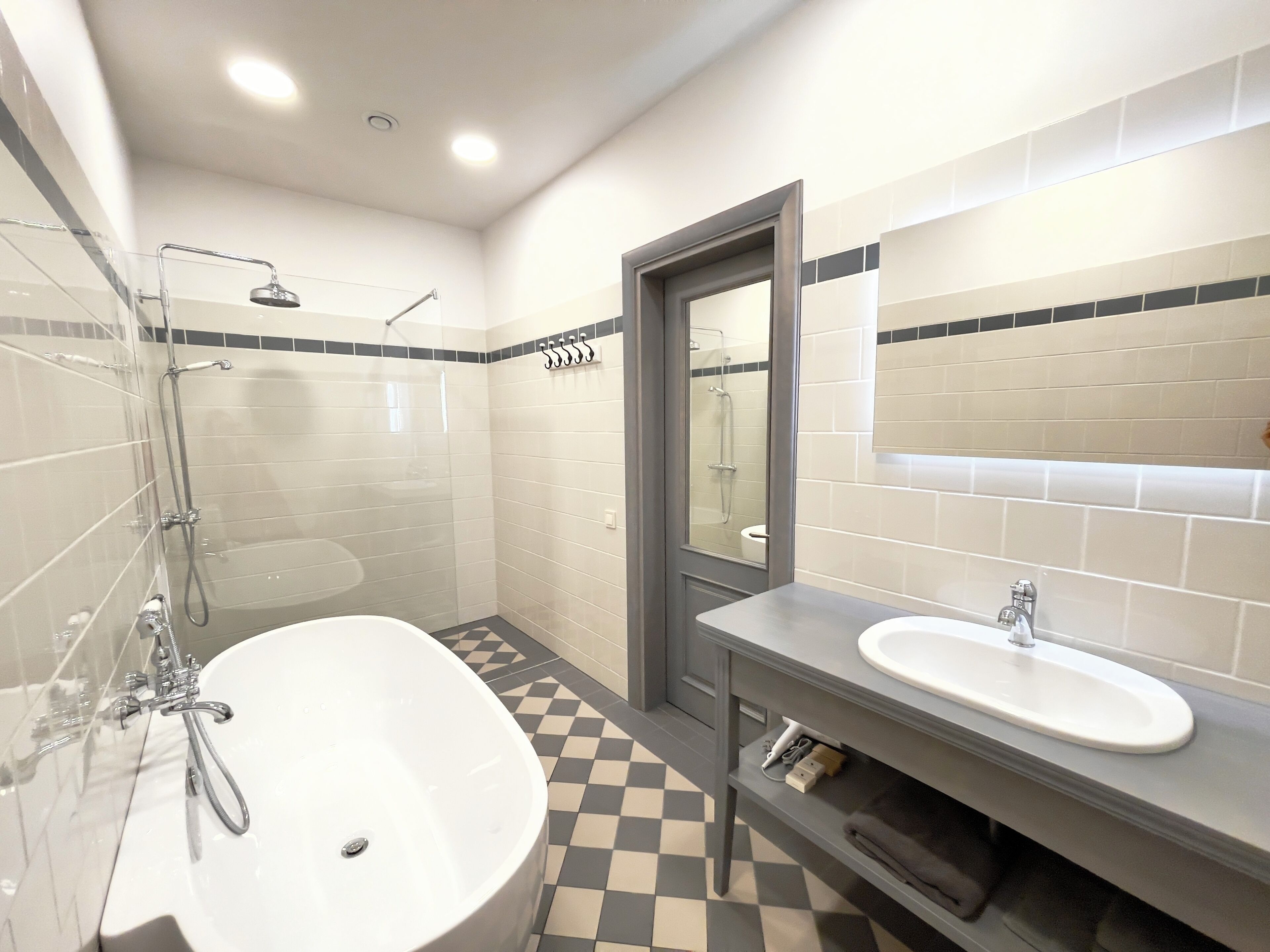 A modern bathroom with a large bathtub, a separate shower area, and a vanity with a sink.