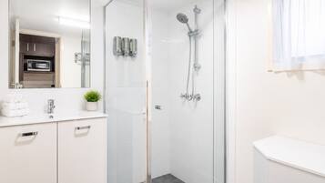Habitación, 1 cama King size | Baño | Regadera, amenidades de baño gratuitas, secadora de cabello, toallas