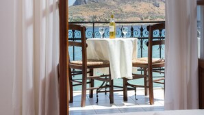 Un balcón con una mesa para dos, con vistas a un paisaje montañoso.