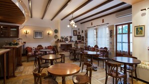 Un comedor acogedor con mesas y sillas de madera, una chimenea y vistas al exterior a través de amplios ventanales.