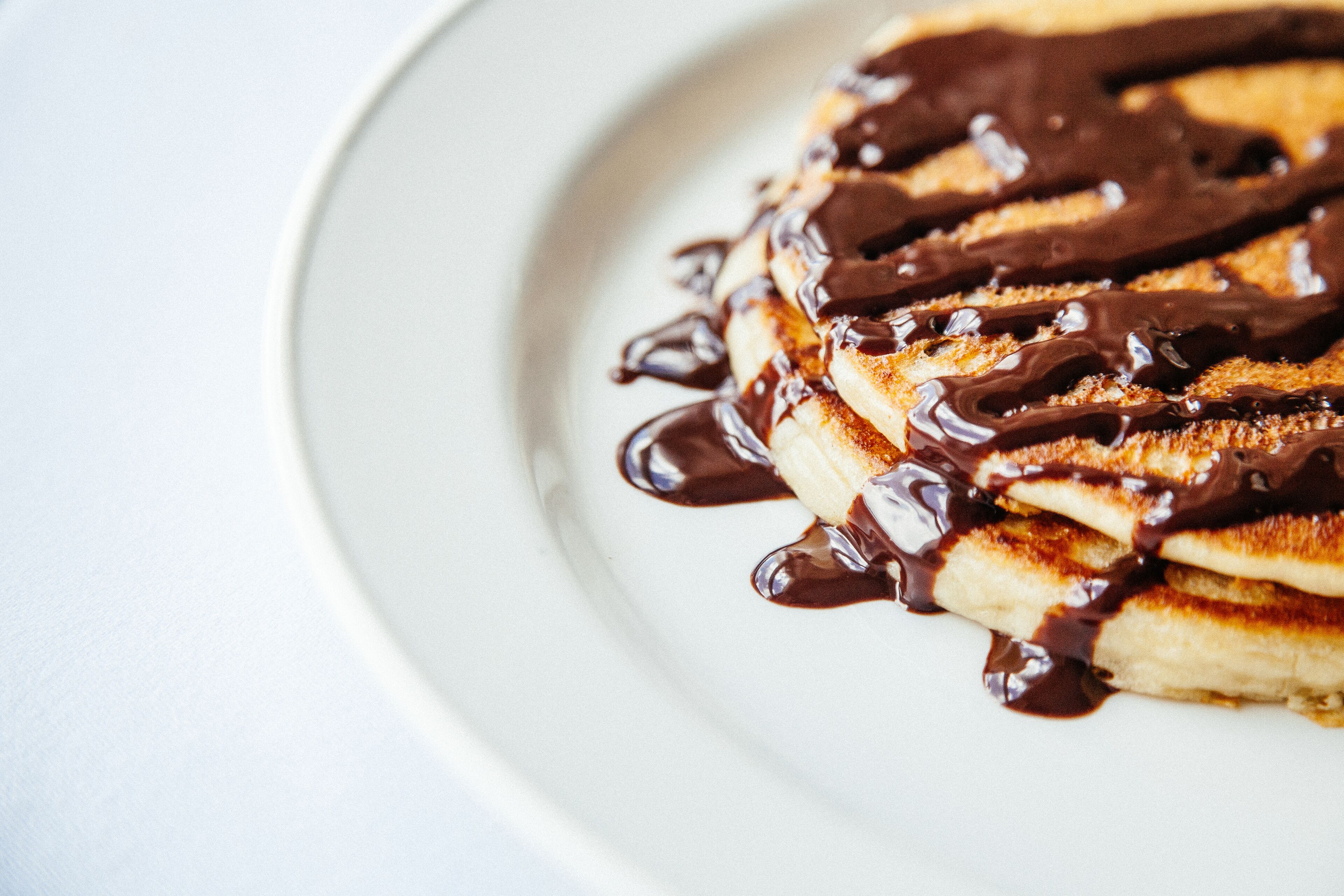 A plate of pancakes with chocolate sauce.