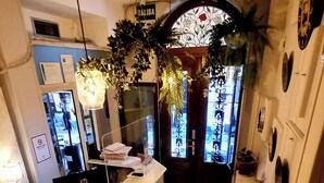 Un área de recepción con mostrador, computadora y un letrero que dice 'SALIDA'.