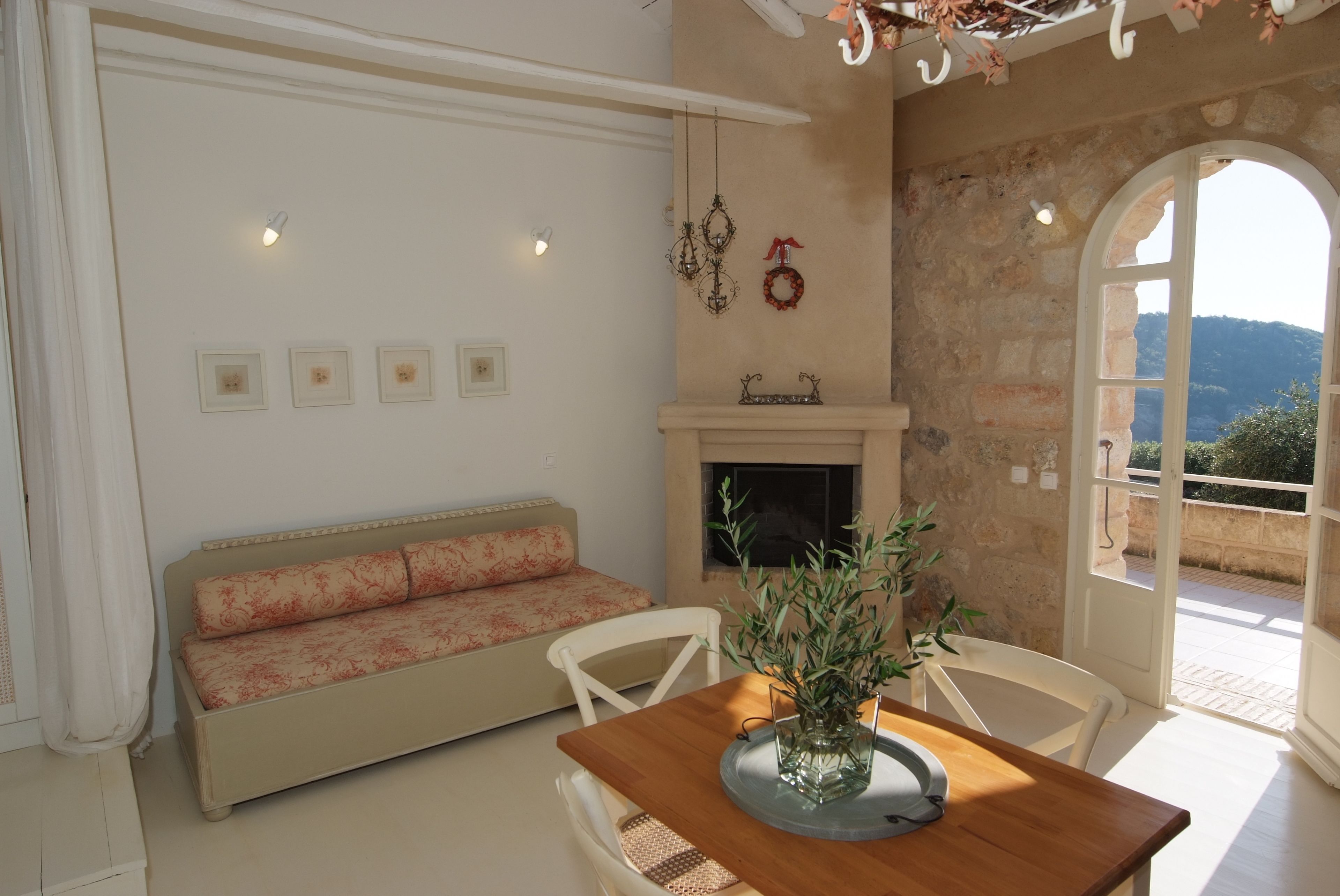 A cozy living room with a sofa, a wooden dining table, and a fireplace.