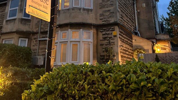 Un edificio con un cartel que dice "The Bath House Boutique B&B" y un aviso de "No hay habitaciones disponibles".