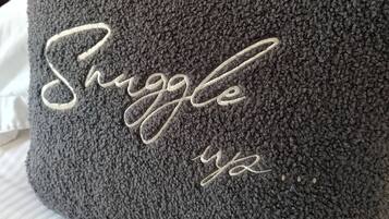 A dark gray textured pillow with the word "Struggle" embroidered in white.