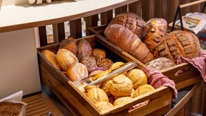 Une vitrine de boulangerie présentant une variété de pains et de pâtisseries.