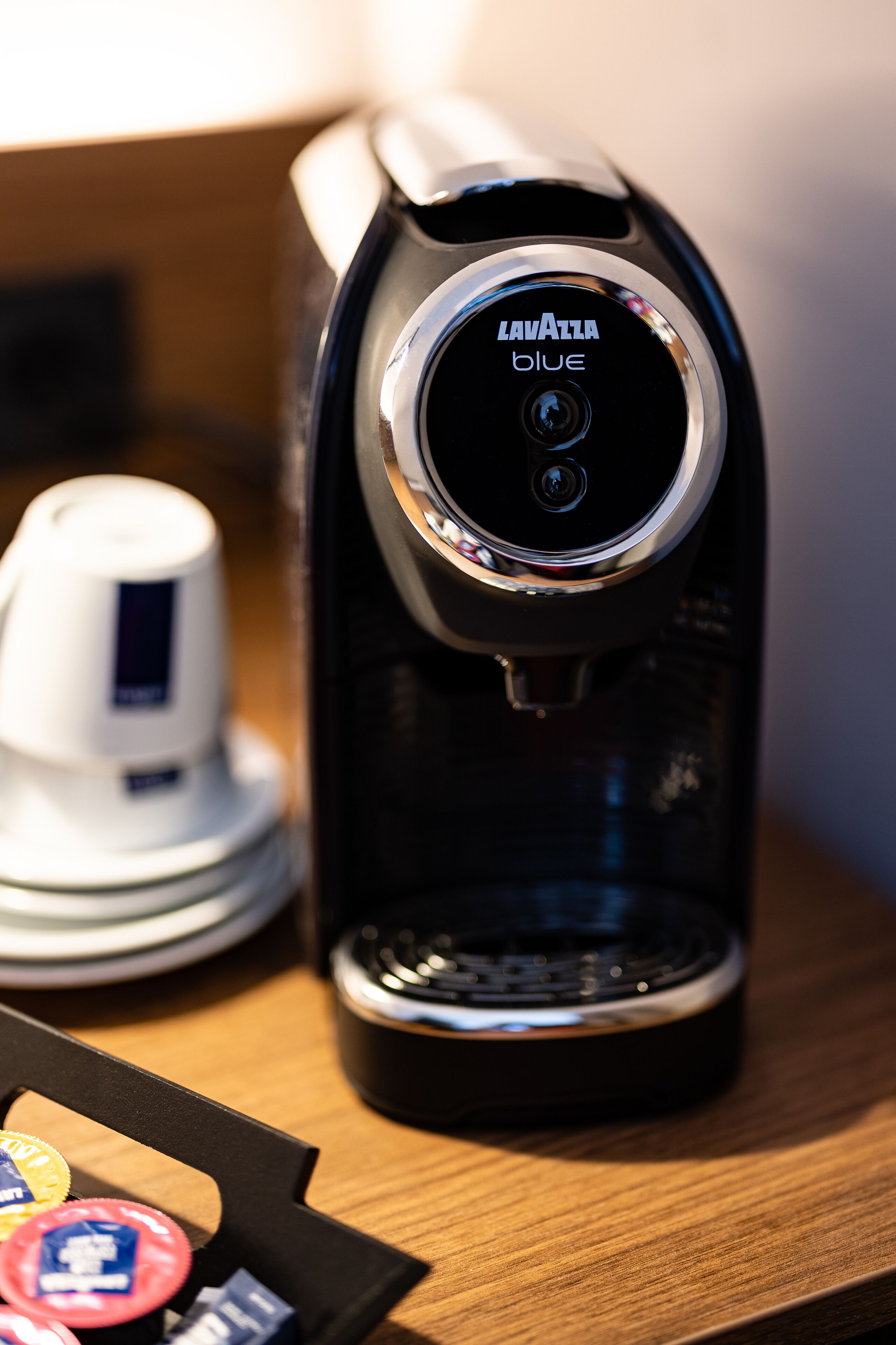 A coffee maker with the brand name "Lavazza Blue" on a wooden surface.