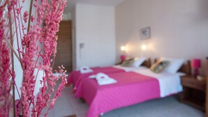 A hotel room with a bed, bedside tables, and a wall-mounted light fixture. - Athena Apartments & Studios (Kithira)