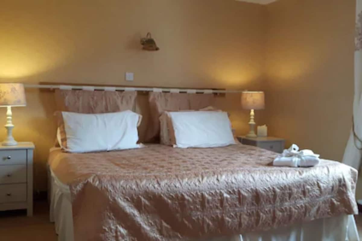 A bedroom with a bed, two bedside tables, and a nightstand.