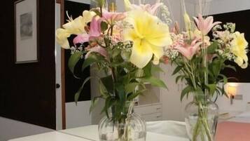 A white reception desk with vases of flowers.