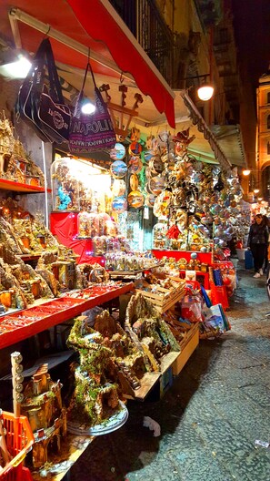 A brightly lit market stall with various items for sale, including figurines and decorative objects. - MAISON DEGAS dimora de charme (Naples)