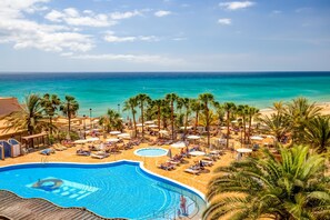 A resort with a swimming pool, beach, and palm trees. - SBH Taro Beach Hotel (Pajara)
