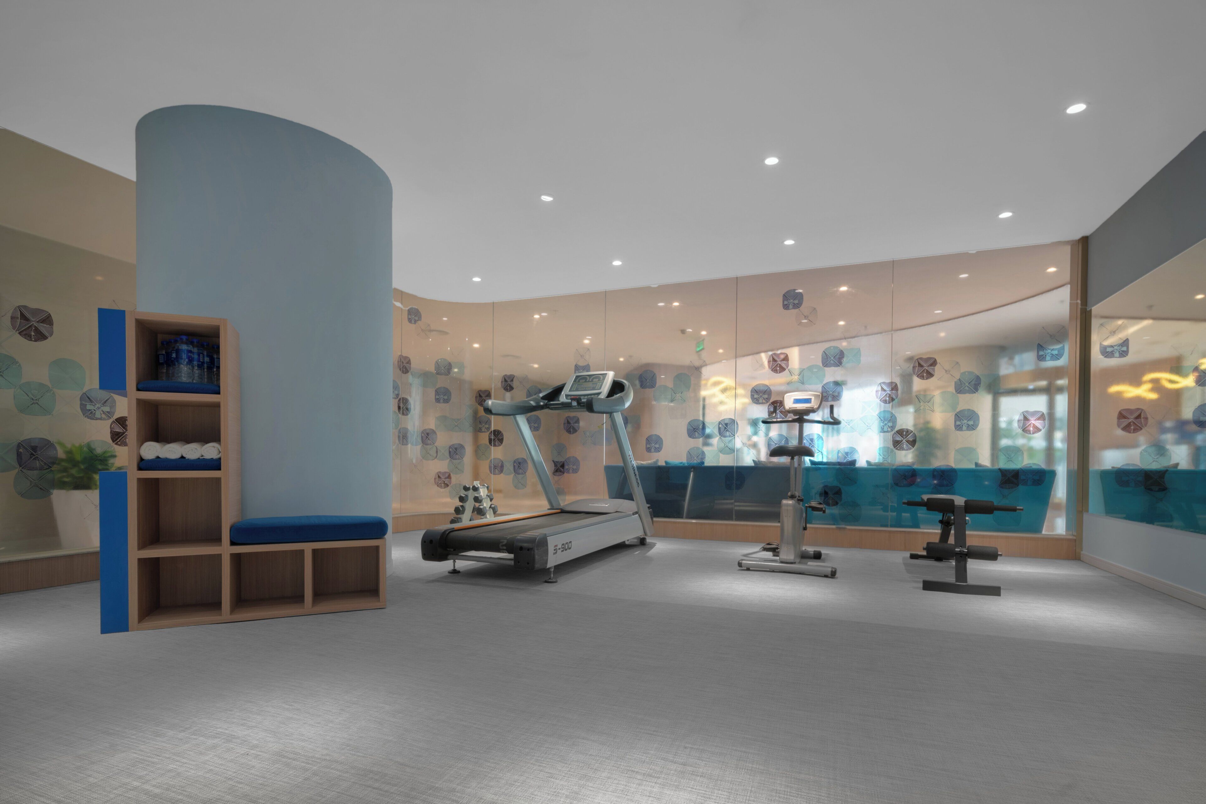 A fitness room with a treadmill, stationary bike, and weight bench.