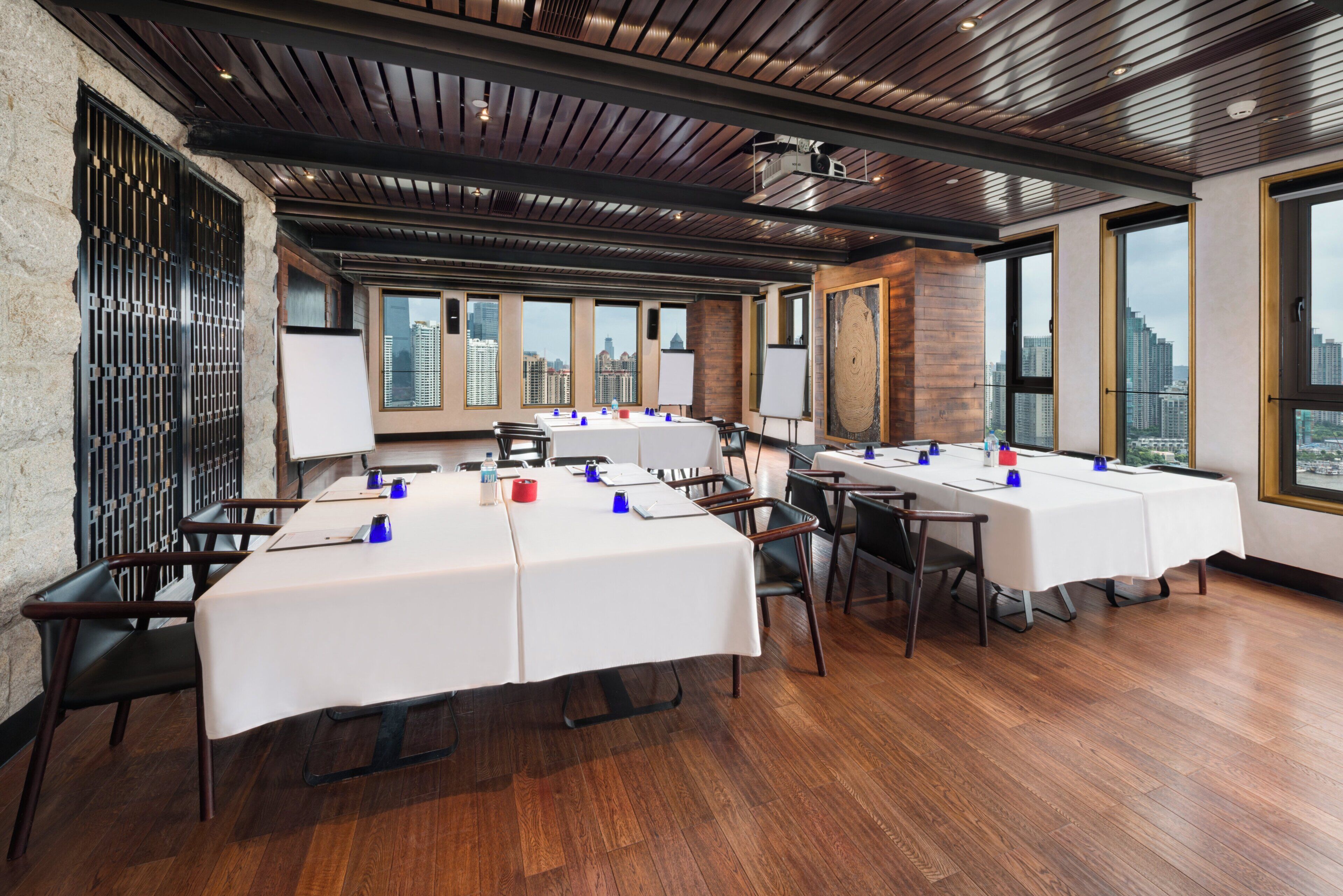 A conference room with multiple tables, chairs, and a projector.