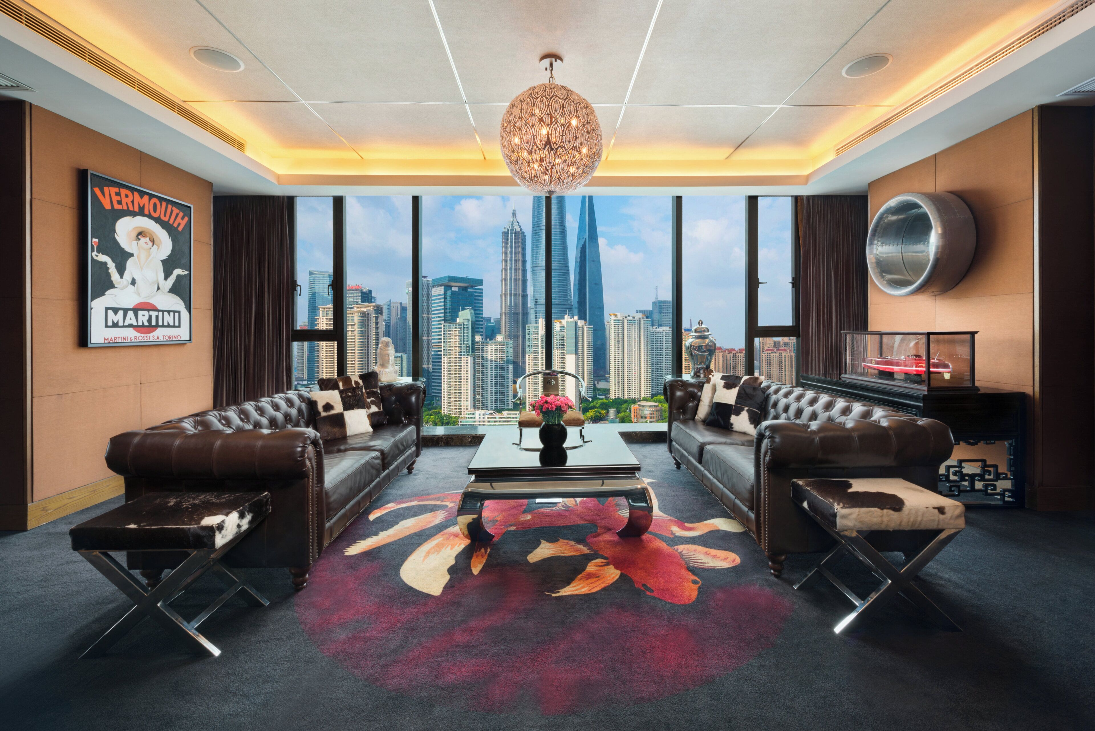 Ein modernes Wohnzimmer mit Ledersofas, einem Couchtisch und einem großen Fenster mit Blick auf die Stadt.
