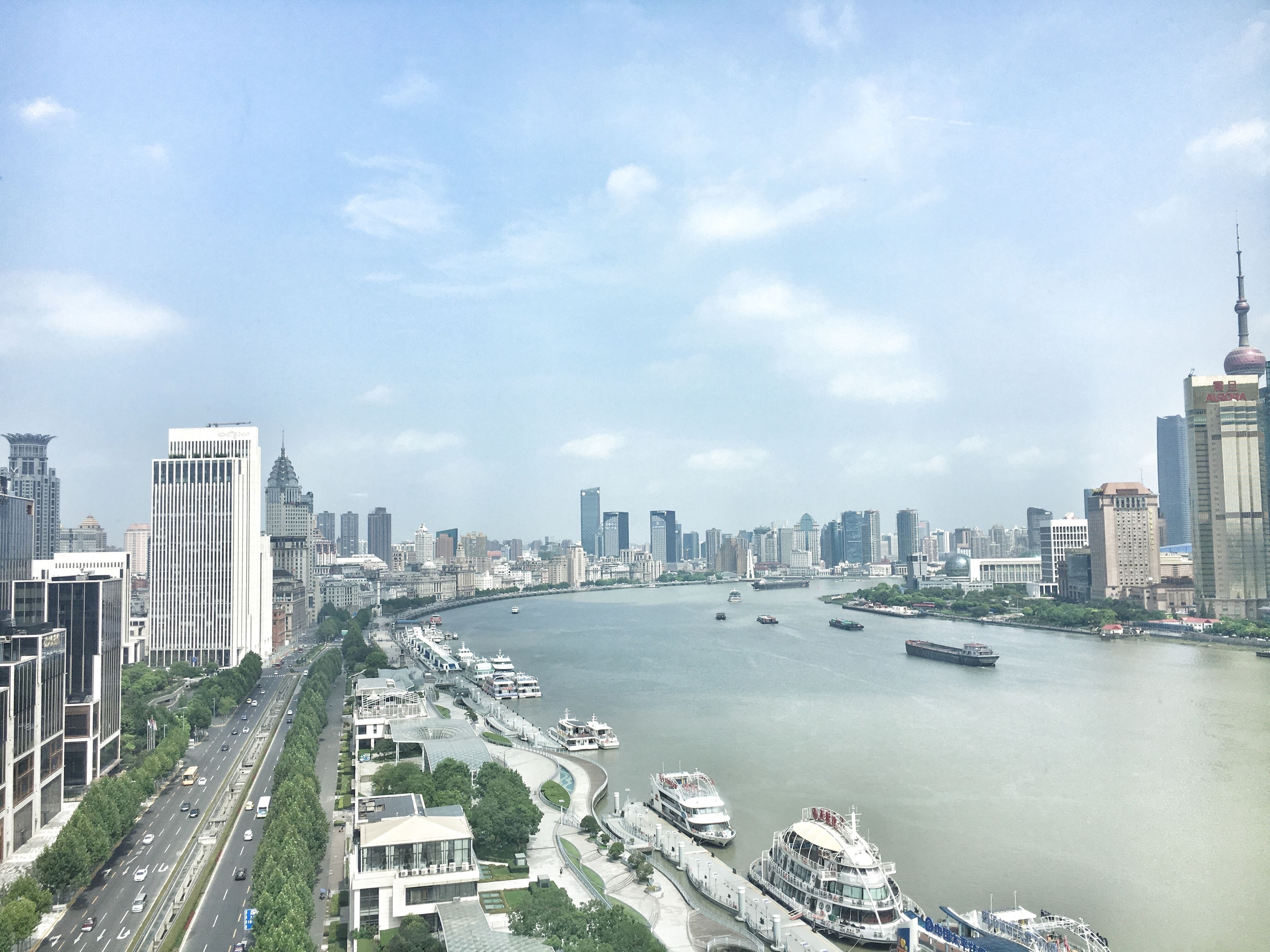 A cityscape with a river, modern buildings, and a bridge.