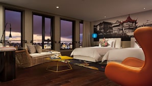 Ein Hotelzimmer mit Blick auf die Stadt, inklusive einer Couch, zwei Betten, einem Schreibtisch und einem Stuhl.