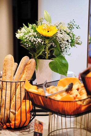 Une table avec du pain et une composition florale.