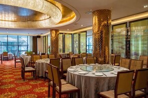 A restaurant with round tables, chairs, and a patterned carpet. - Fubang International Hotel (Hangzhou)
