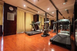 A gym with treadmills, stationary bikes, and a weight machine. - Fubang International Hotel (Hangzhou)