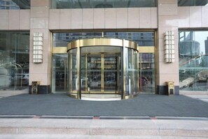 A revolving door entrance to a building with a glass facade and a metal frame. - Fubang International Hotel (Hangzhou)
