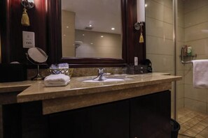A bathroom with a double sink, a mirror, a towel, and a shower area. - Fubang International Hotel (Hangzhou)