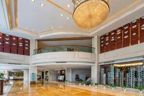 A spacious lobby with a high ceiling, a central chandelier, and a curved balcony overlooking the area. - Fubang International Hotel (Hangzhou)
