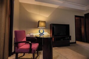 A hotel room with a single bed, a TV, a small table, and a chair. - Fubang International Hotel (Hangzhou)