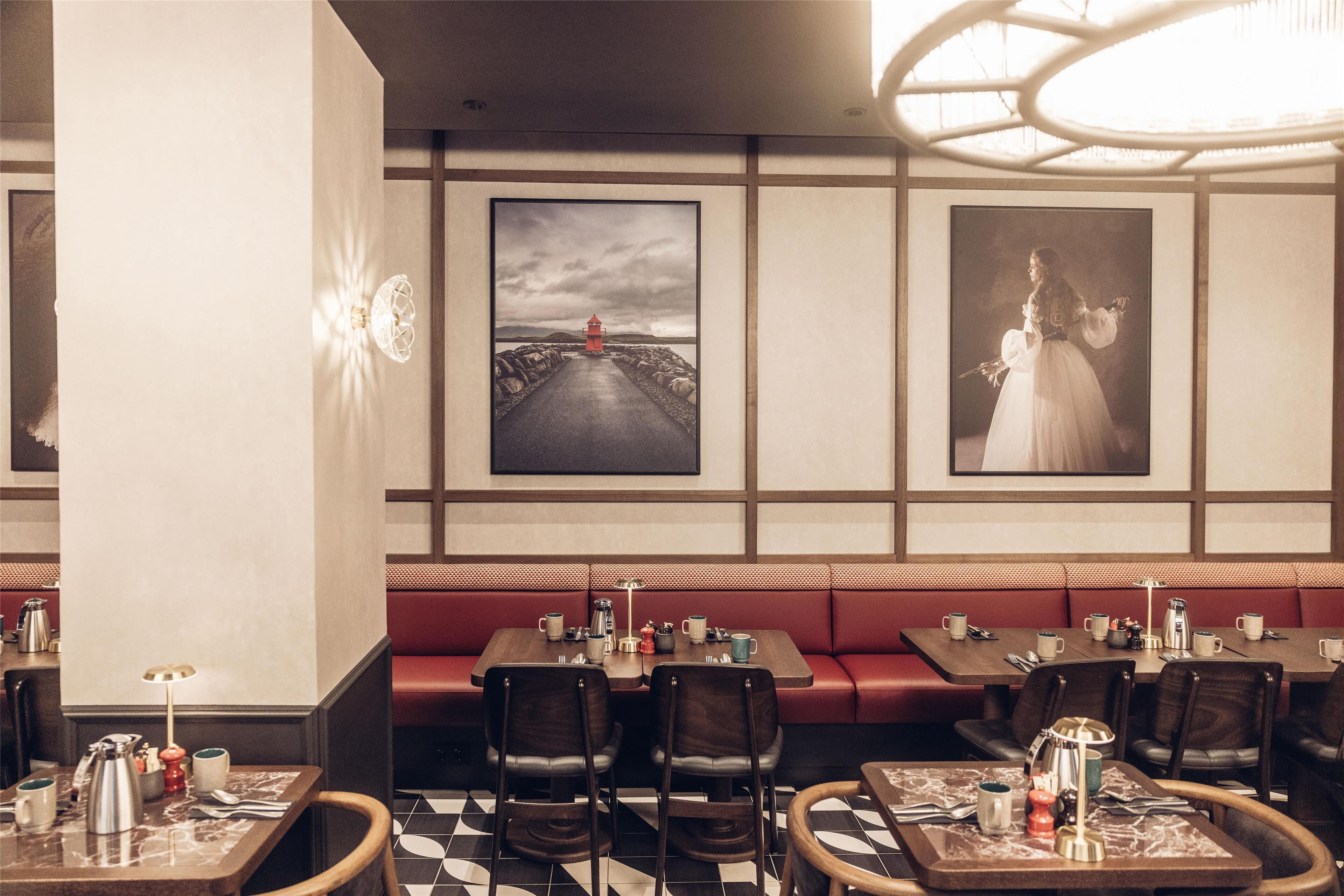 A restaurant with red booths, wooden tables, and black and white checkered flooring.